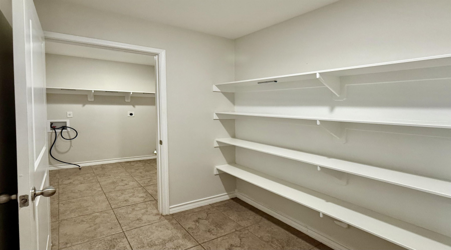 Storage room that connects to the laundry room and the kitchen.