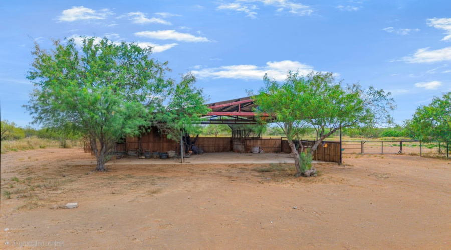 Corral area with stables, half bath, storage area and large covered area for parking or gatherings.